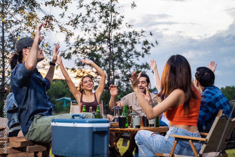 Group of diverse friend having outdoors camping party together in tent. 