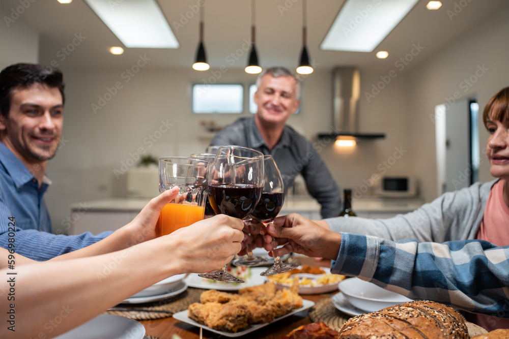 Multi-ethnic big family having dinner, enjoy evening party in house. 