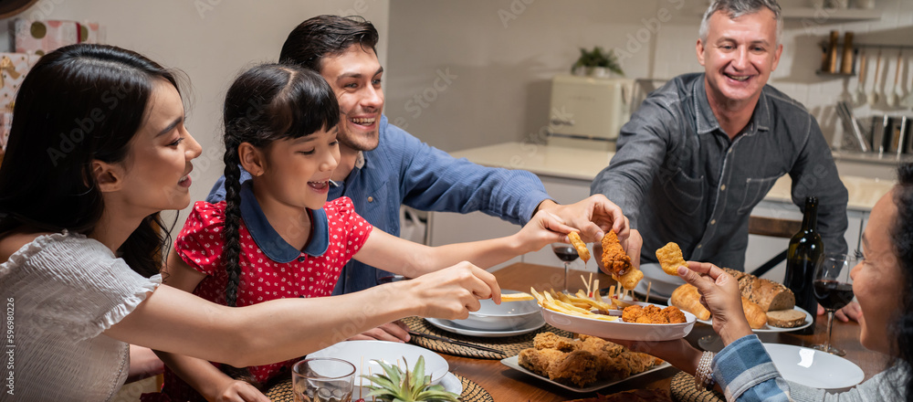 Multi-ethnic big family having dinner, enjoy evening party in house. 