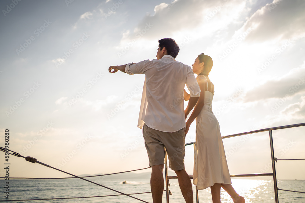 Asian beautiful couple drinking champagne while having party in yacht. 