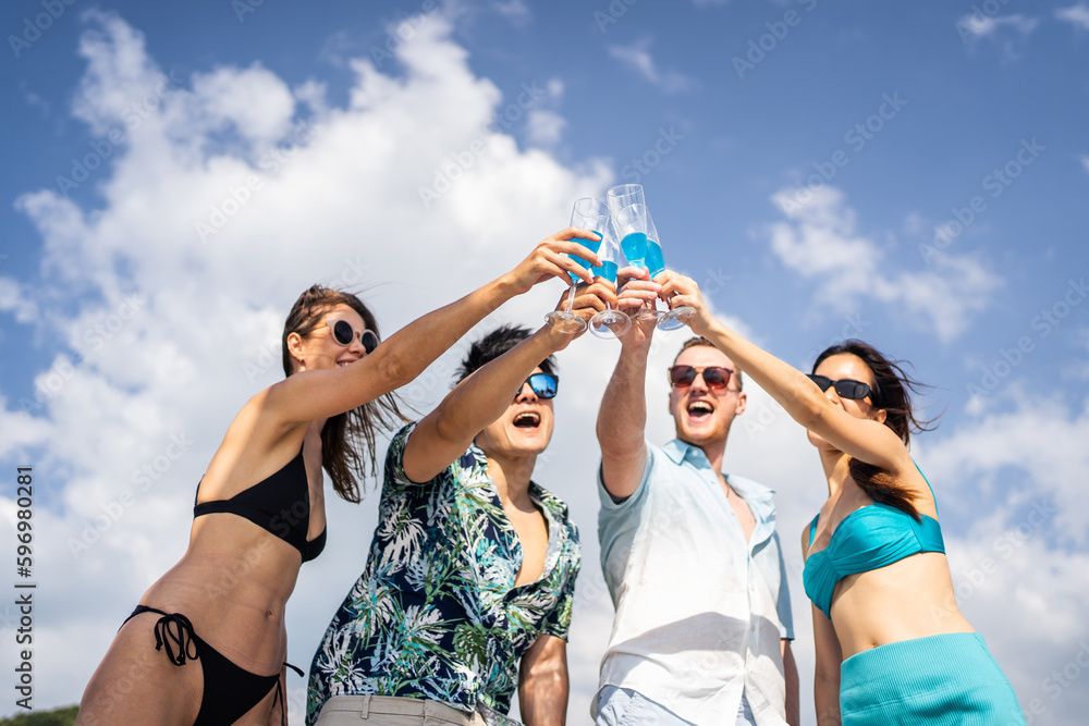 Group of diverse friends drink champagne while having a party in yacht. 