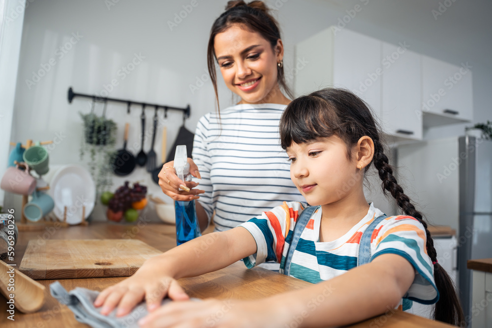 Caucasian beautiful mother cleaning house with young kid daughter. 