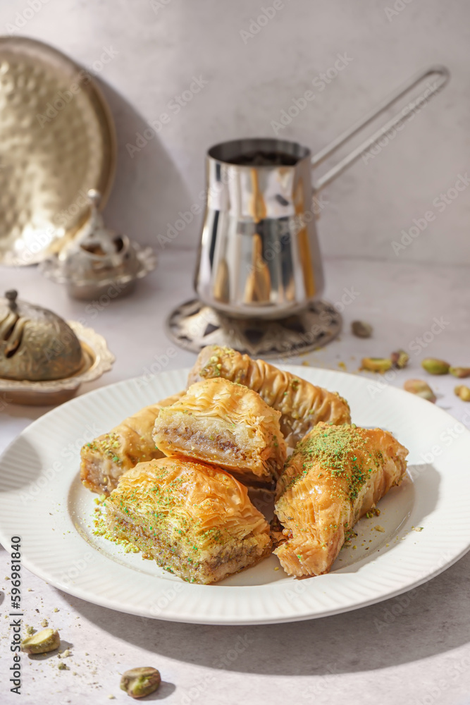 Plate of tasty baklava on light background