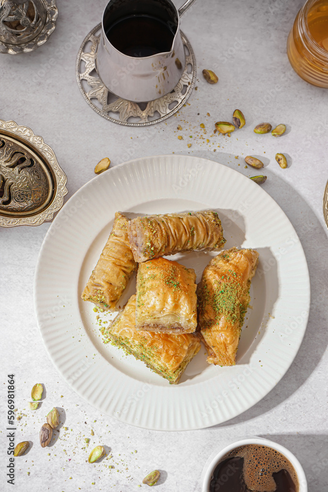 Plate of tasty baklava on light background