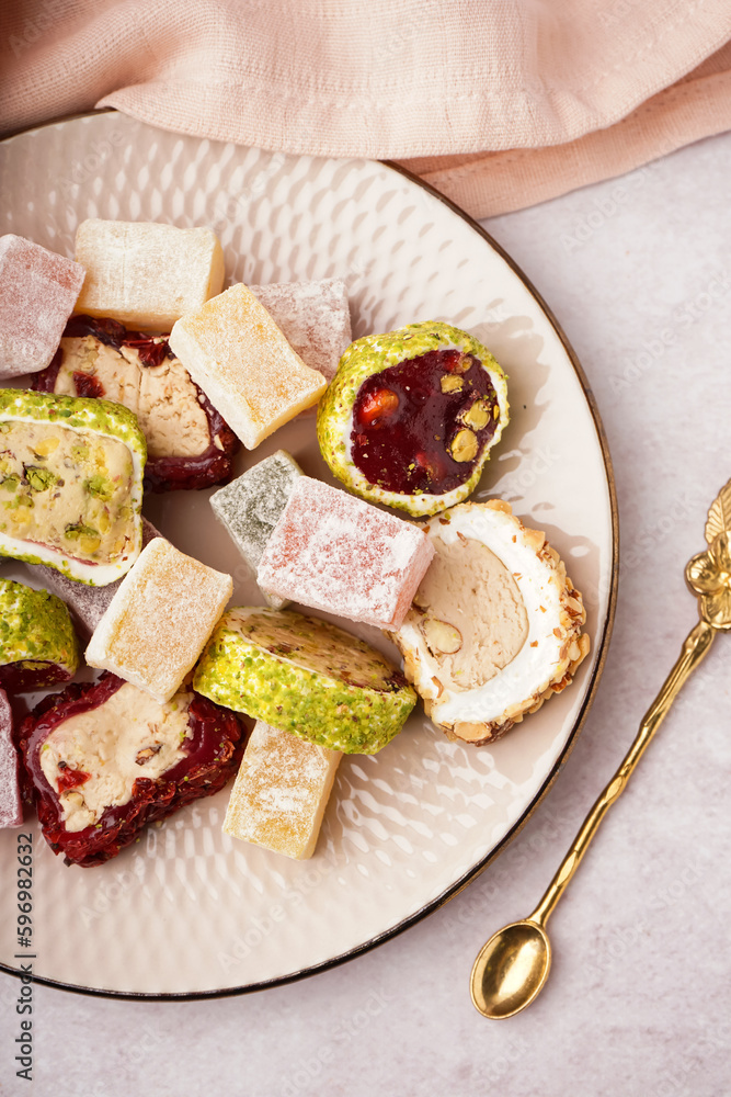 Plate with tasty Turkish Delight on light background, closeup