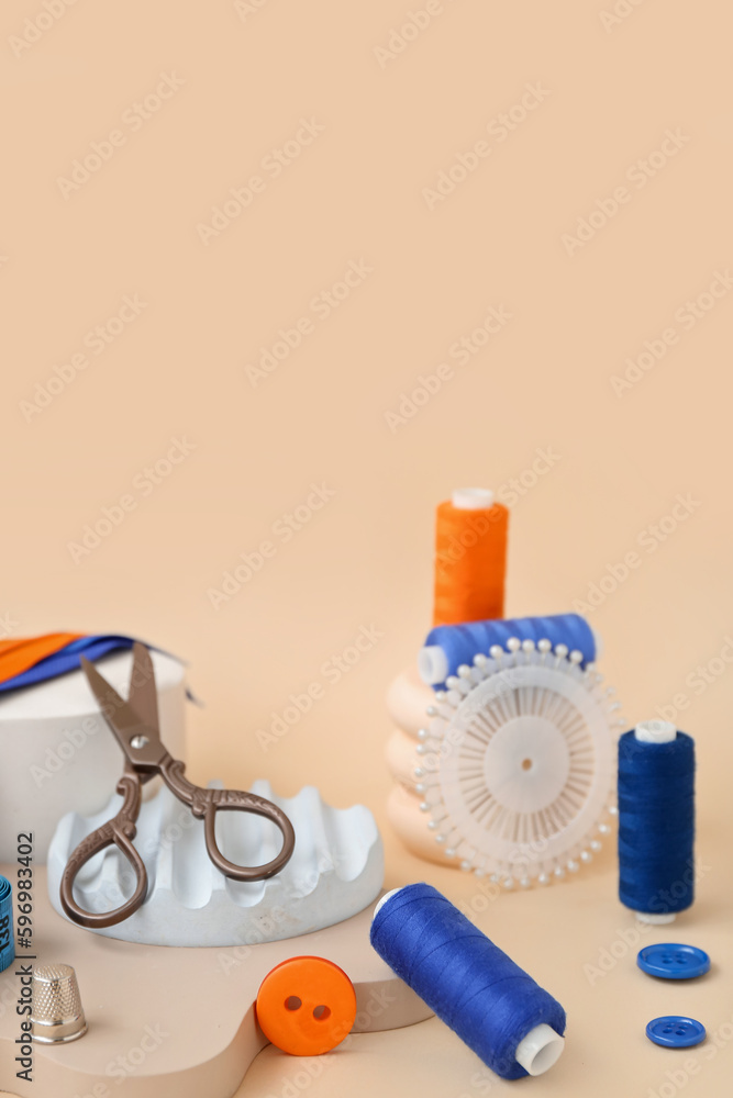 Podiums with tailors supplies on beige background