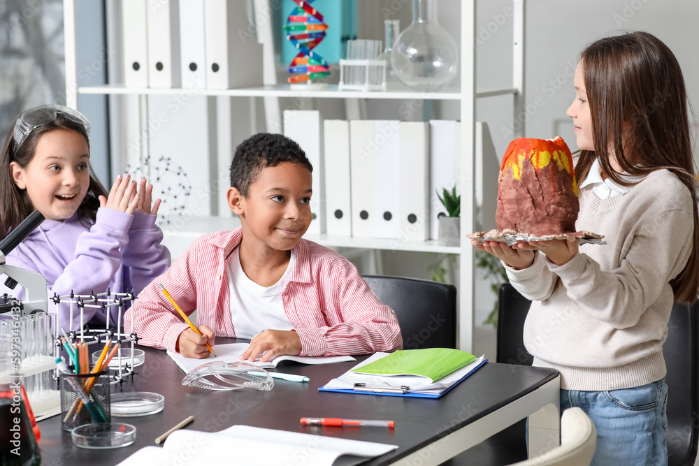 Little children with chemical volcano in science classroom