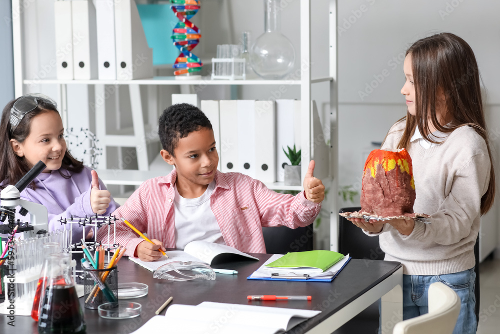 Little children with chemical volcano in science classroom