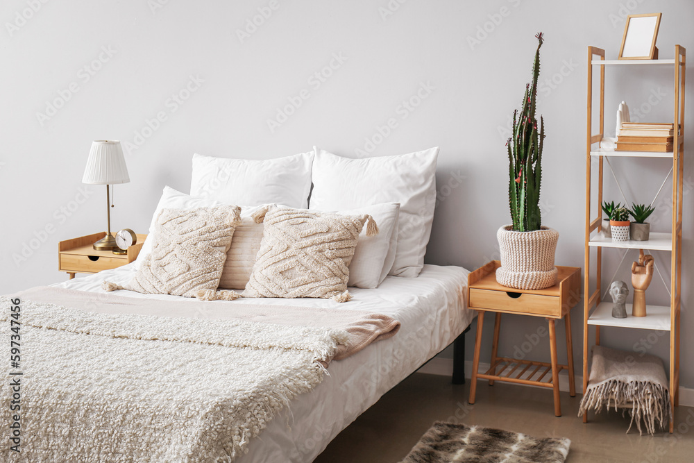 Interior of cozy bedroom with big cactus in pot