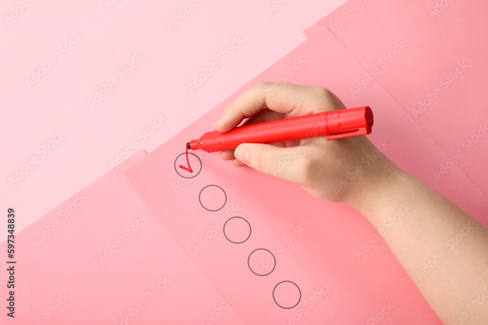 Woman marking on checklist box with red marker