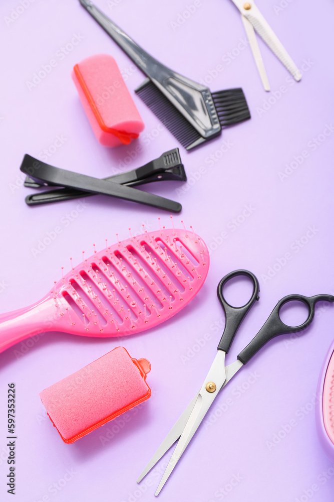 Frame made of hairdressing accessories on lilac background, closeup