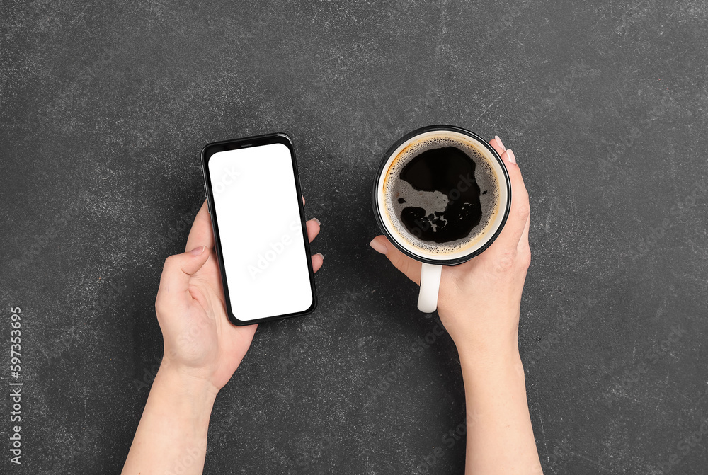 Woman with cup of coffee and mobile phone on dark background