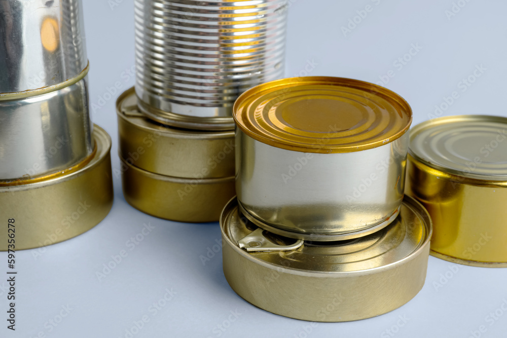 Different tin cans with fish on white background