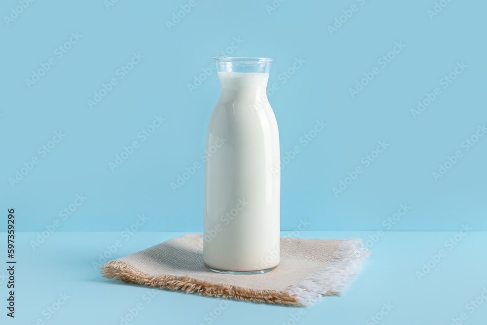 Bottle with fresh milk on blue background