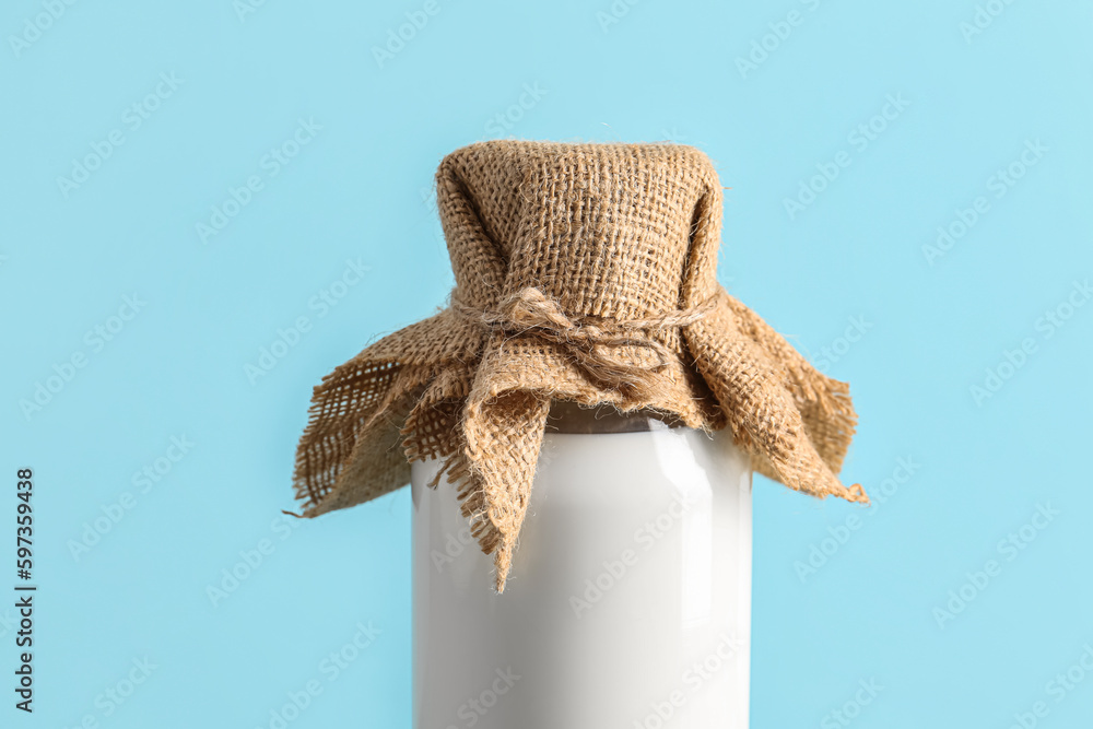 Bottle with fresh milk on blue background