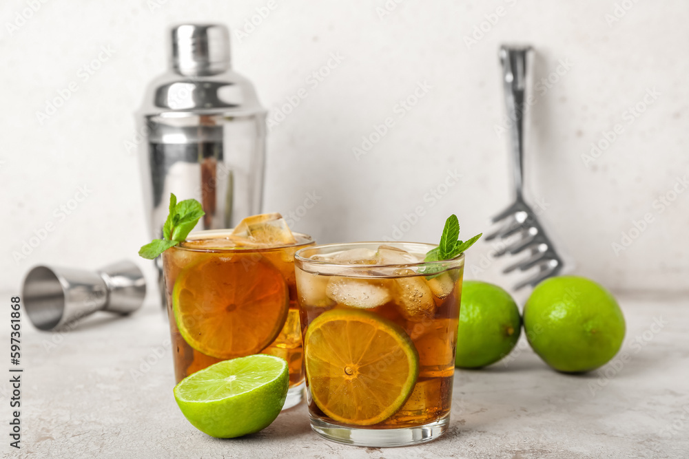 Glasses of tasty Cuba Libre cocktail on light background