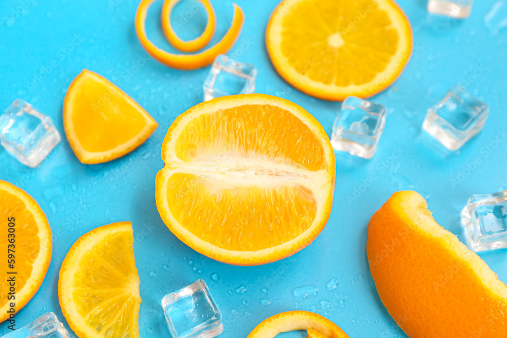 Orange pieces with ice cubes on blue background