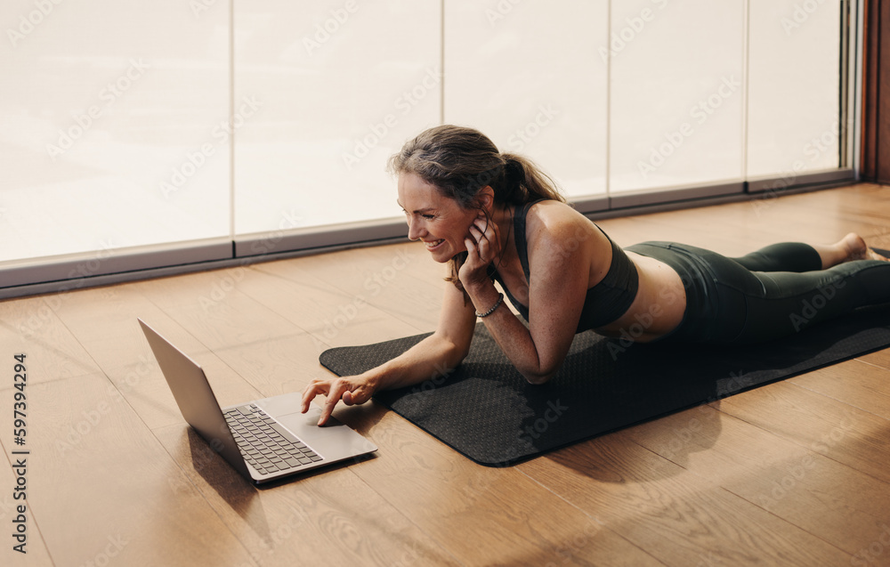 Elderly woman joining an online fitness class on a laptop