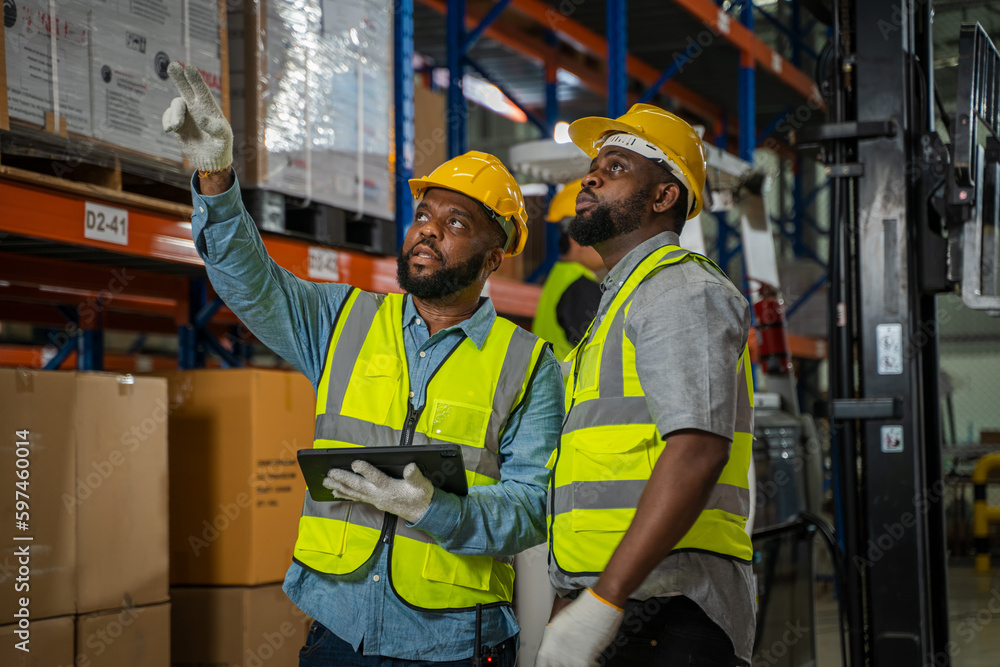 Warehouse employees reading a clipboard in a logistics centre,Warehouse worker taking packages for s