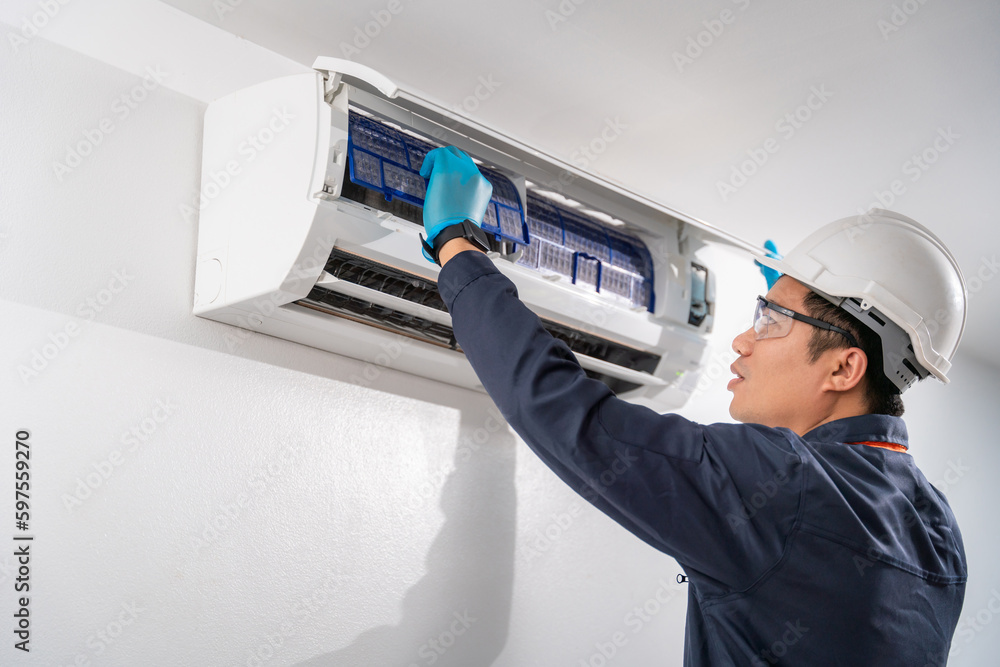 Air technician wear uniform service removing air filter of the air conditioner for cleaning on white