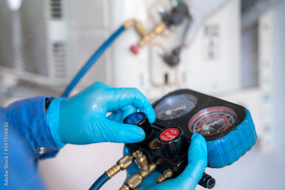 Close-up hand of Air conditioner technician is checking air conditioner ,measuring equipment for fil