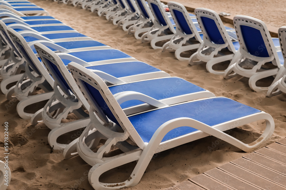 Sun loungers on sand in water park