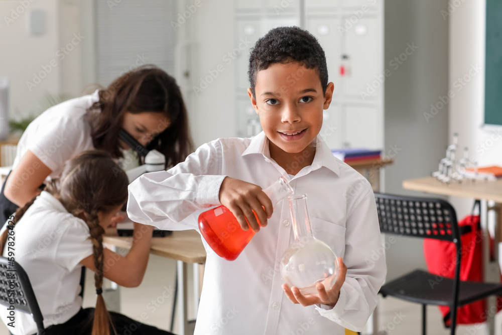 African-American little boy with flasks in science classroom