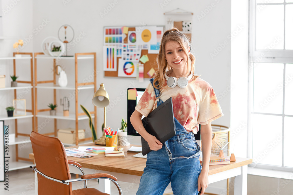 Female graphic designer working with tablet in office