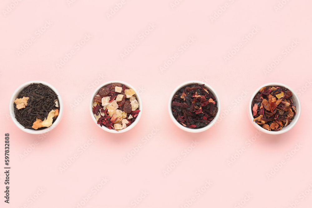 Bowls with different dried fruit tea on pink background