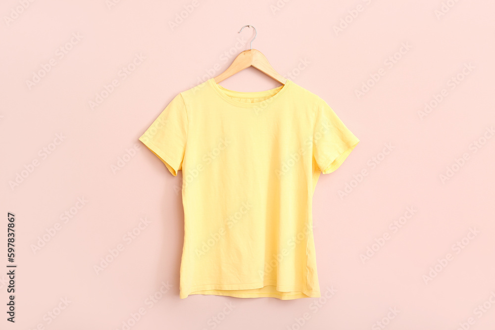 Yellow t-shirt hanging on pink wall