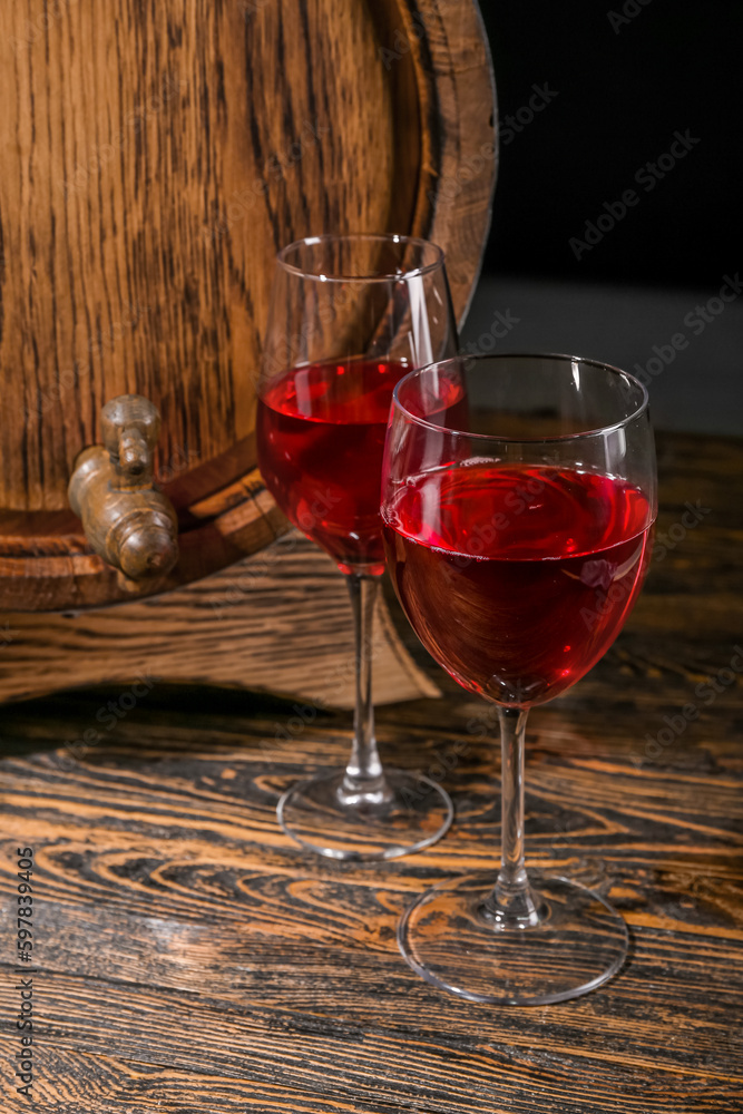 Wooden barrel with glasses of wine on table