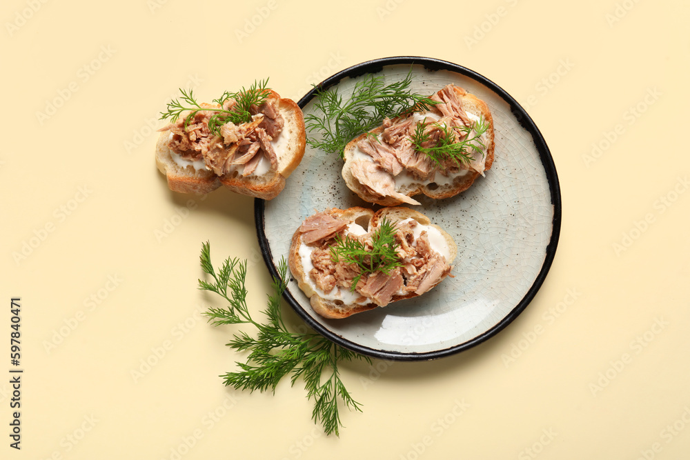 Plate with delicious tuna bruschettas on beige background