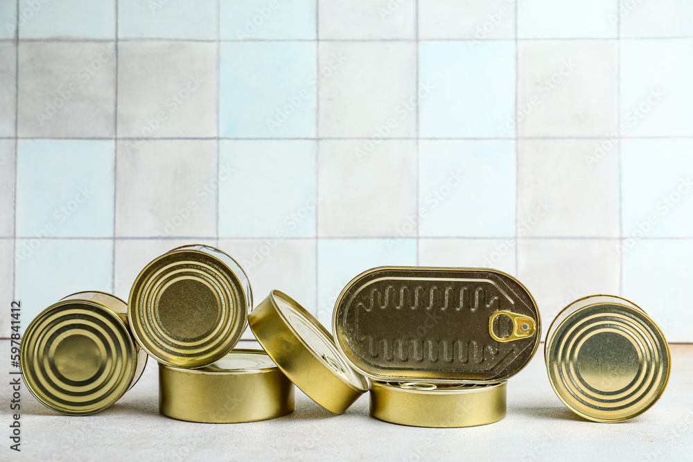 Tin cans with fish on white table