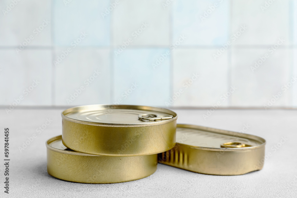 Tin cans with fish on white table