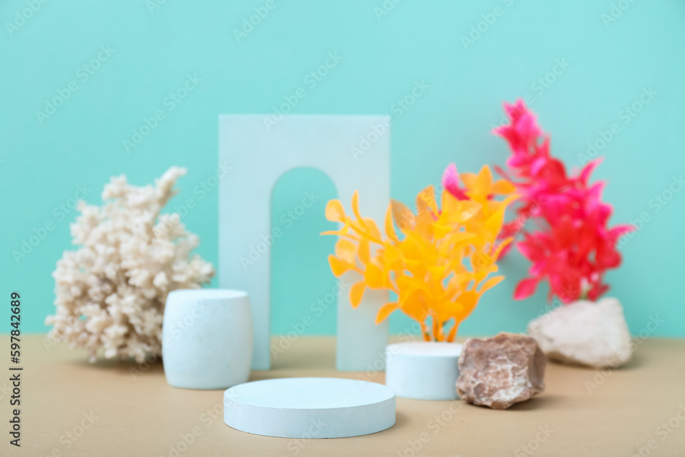 Decorative plaster podiums, seaweed and coral on turquoise background