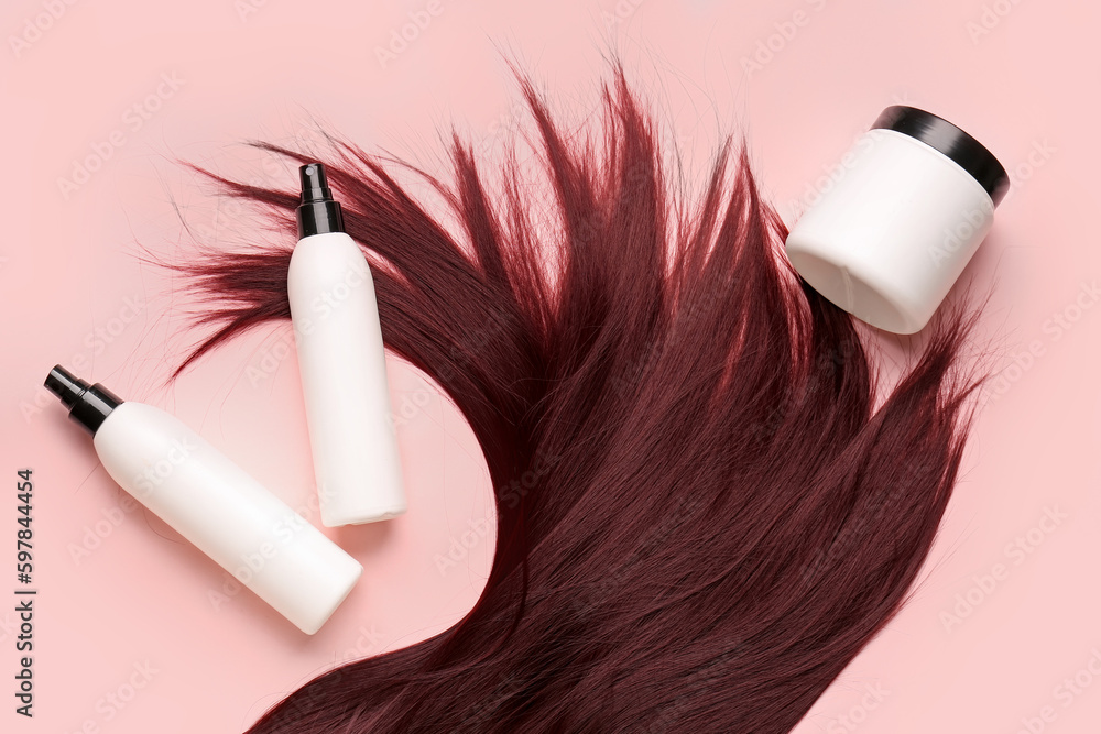 Red brown hair with cosmetic products on pink background