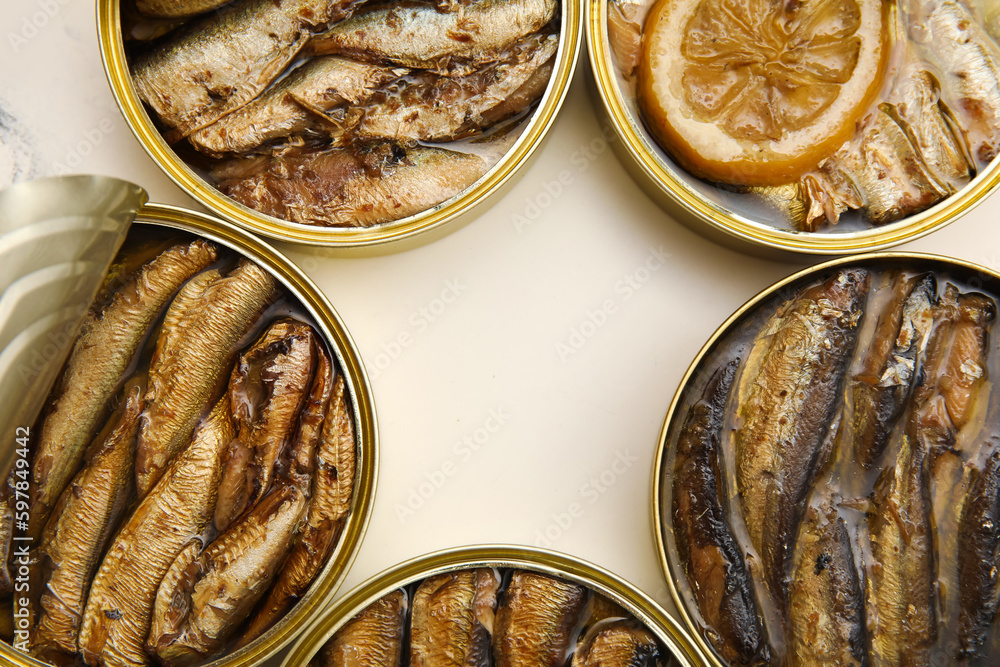 Opened tin cans with sprats in oil on white table