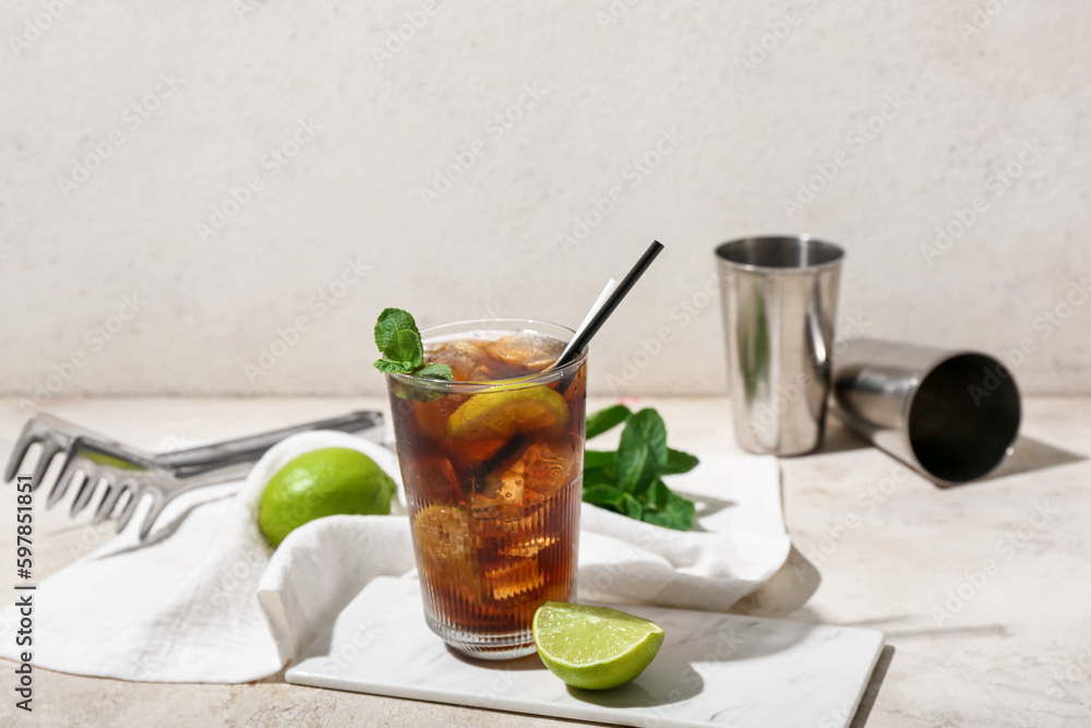 Glass of tasty Cuba Libre cocktail on light background