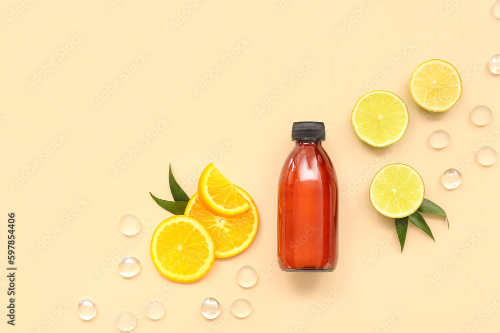 Bottle of cosmetic product with fruits slices and glass stones on beige background