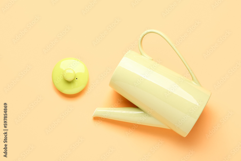 Stylish ceramic teapot on orange background