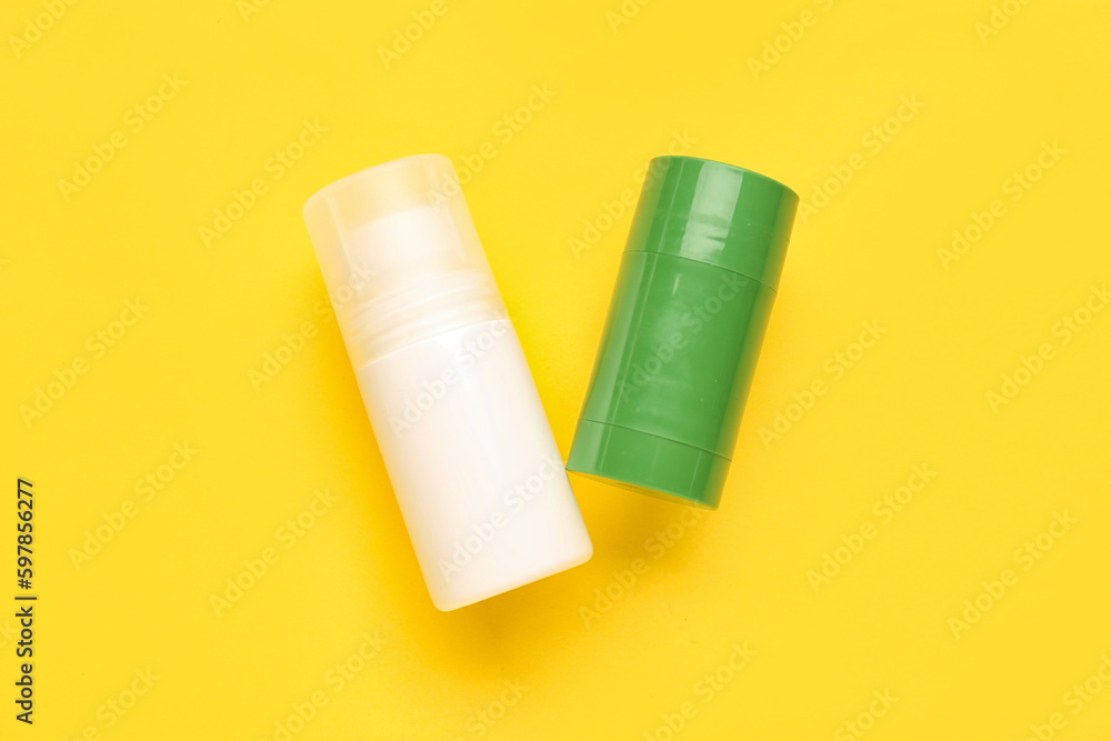 Different deodorant bottles on yellow background