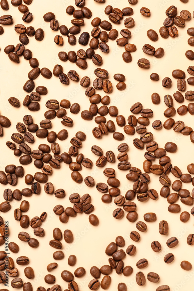 Scattered coffee beans on pale yellow background