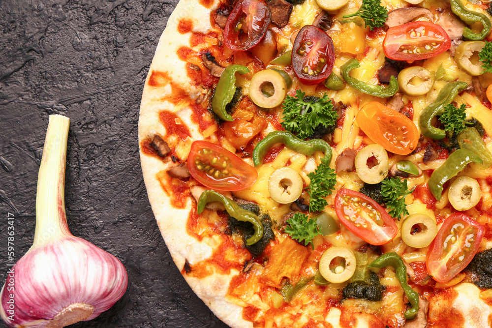 Vegetable pizza with garlic on dark background