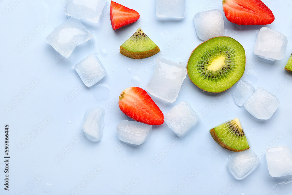 Sliced fresh strawberry with kiwi and ice cubes on blue background