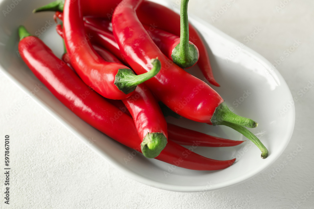 Plate of fresh chili peppers on light background, closeup