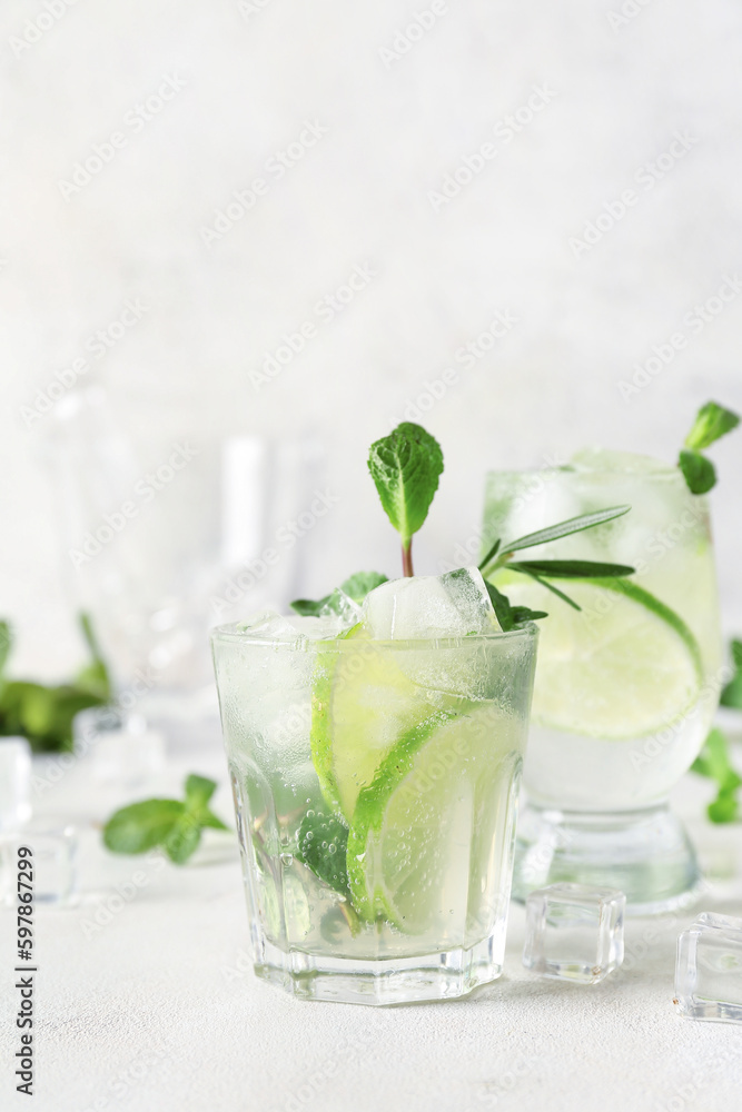 Glass of tasty mojito on light background