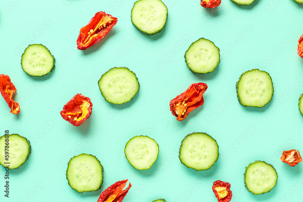 Slices of cucumber with dried tomatoes on turquoise background