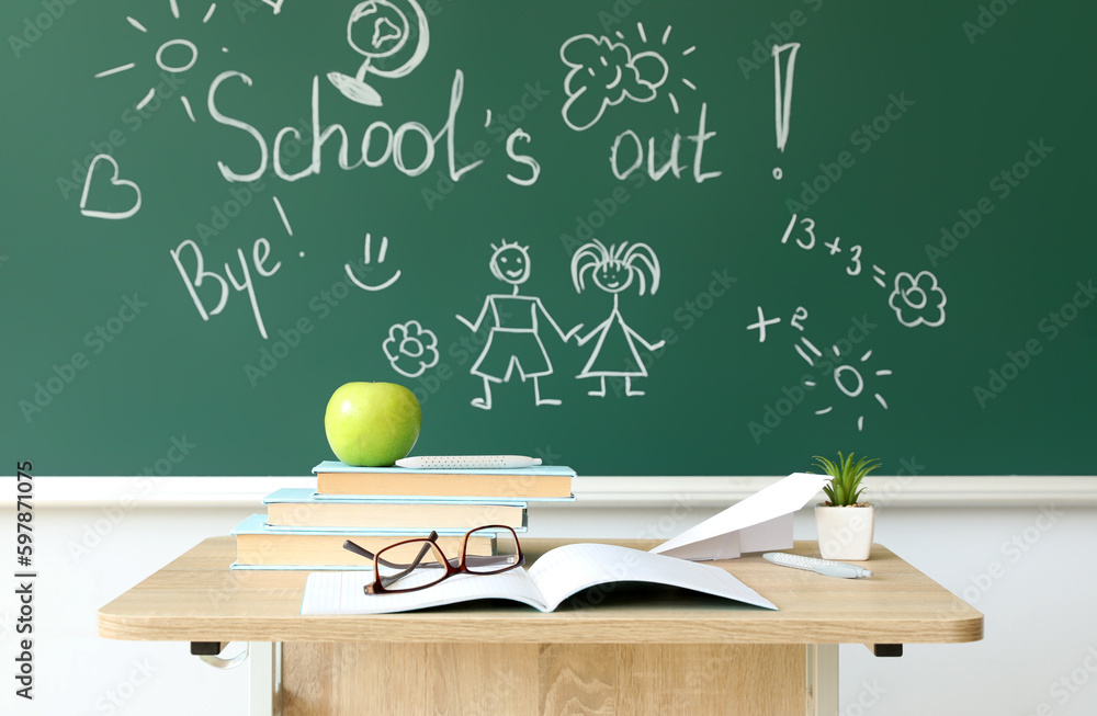 Text SCHOOLS OUT with drawings on blackboard in classroom