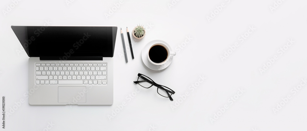 White office desk table with laptop, coffee cup, pencils and eyeglasses. Top view with copy space, f