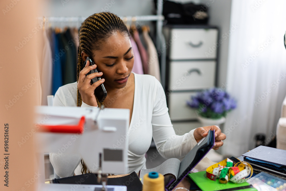 African American women fashion designer working in a tailoring atelier. 